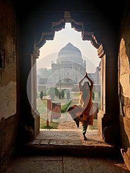 Caucasian female doing yoga in Bada Gumbad Complex at early morning in Lodi Garden photo