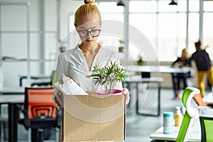 Caucasian female employee intern holding cardboard box with belongings start or finish job