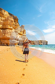 Caucasian female with a hat on the beach at Praia da Coelha, Algarve, Albufeira. Portugal