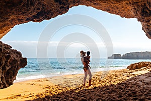 Caucasian female with her son in the natural cave in the Algarve at Praia da Coelha, Albufeira