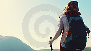 Caucasian female hiker stand enjoy panorama on hilltop on hiking trail outdoors in sunny day on Levanis lake trek in Georgia