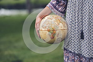 Caucasian female holding a globe figure