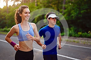 Caucasian female sports woman and fit man in full body length running pine forest road. healthy lifestyle concept