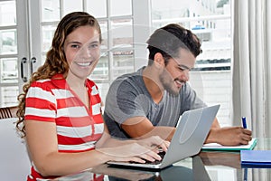 Caucasian female student at computer with latin american guy