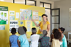 Caucasian female teacher teaching environmental conservation to african american elementary students