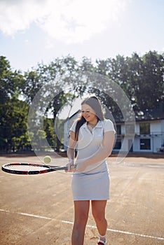 Caucasian female tennis player playing on the court outdoors