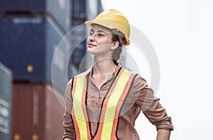 Caucasian female worker standing in front of containers