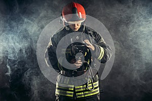 Caucasian fireman in uniform stand in smoke