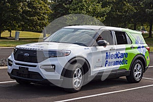 A caucasian first responder is waiting inside a Ford interceptor paramedic car