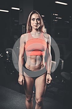 Caucasian fitness female model in gym close up abs