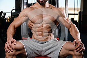 Caucasian fitness model in gym close up abs