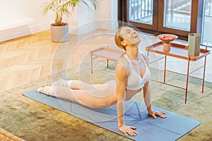 caucasian fitness woman practicing yoga at home