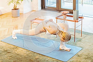 caucasian fitness woman practicing yoga at home