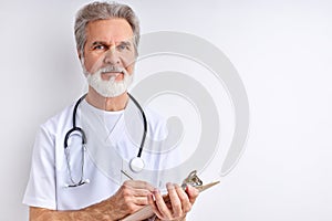 Caucasian friendly senior doctor taking medical history of patient