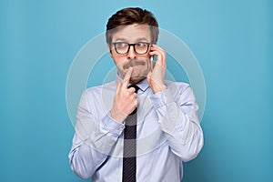 Caucasian funny man with glasses having a stressful conversation with his boss.