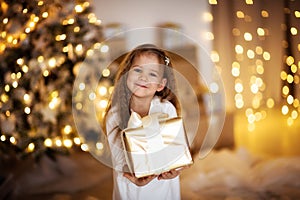 Caucasian girl with blond long hair Christmas gift, golden ligh