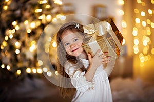 Caucasian girl with blond long hair Christmas gift, golden ligh