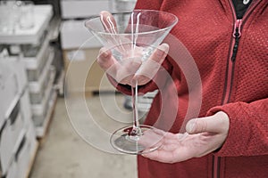 Caucasian girl buys large, transparent glass for martinis and cocktails in store
