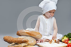 Caucasian Girl in Cook Hat and Lips in Flour Sitting in Front of Fresh Buns