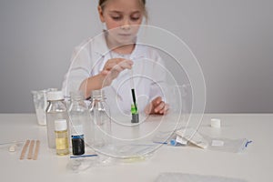 Caucasian girl doing chemical experiments on a white background.