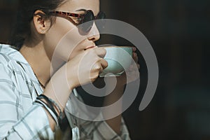 Caucasian girl drinking coffee in cafe, coffee break concept