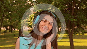 Caucasian girl front view looking camera smiling using headphones