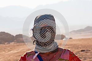 Caucasian girl in head kerchief in the desert