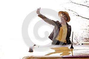 Caucasian Girl Making Selfie out of Car Sunroof