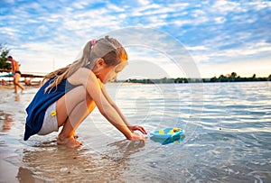 Caucasian girl playing with rubber duck toys on beach.