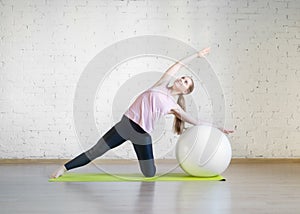 Caucasian girl practise pilates with big fit ball, attractive posing in fitness studio, lifestyle, selective focus.