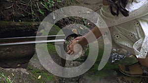 Caucasian girl sat down at a spring and washed her hands with clear water