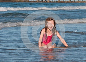 Caucasian girl, sitting on the beach .