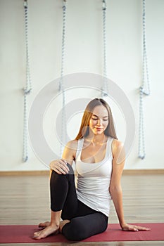 Caucasian girl sitting on mat and wearing casual wear