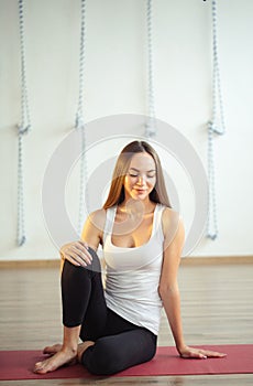 Caucasian girl sitting on mat and wearing casual wear