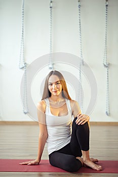 Caucasian girl sitting on mat and wearing casual wear