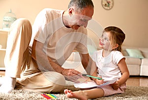 Caucasian girl watching her great grandfather writing.