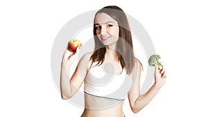 Caucasian girl.Weight loss, slim body, diet, sport, fitness and health concept. young beautiful woman holding broccoli and apple