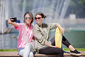 Caucasian girls making selfie background big fountain. Young tourist friends traveling on holidays outdoors smiling