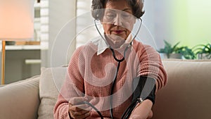 Caucasian grandmother checking low high cardio heart beat senior woman at home old female granny elderly retired lady