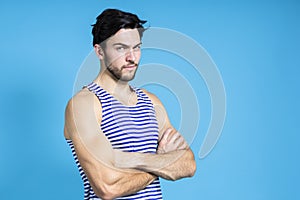 Caucasian Handsome Brunet Man in Striped Underware During Early Morning Posing With Hands Folded In Front Against Seamless Blue