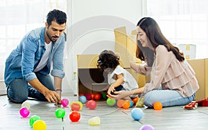 Caucasian handsome father, asian beautiful mother, little mixed race happy adorable girl, daughter sitting on floor, family