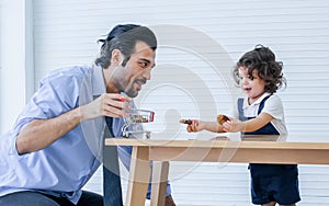 Caucasian handsome father taking care, playing toys with his little cute daughter on floor in cozy living room at home after work