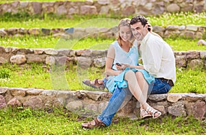 Caucasian Happy Couple Having Good Time Together Outdoors. Using