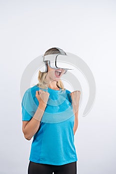 Caucasian happy girl making winner gesture while using VR glasses. Contraption.