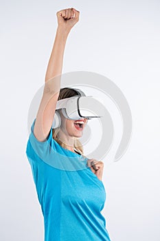 Caucasian happy girl making winner gesture while using VR glasses. Contraption.