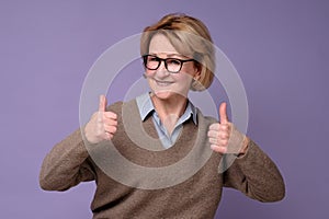 Caucasian happy senior woman showing her two thumbs up approving choice