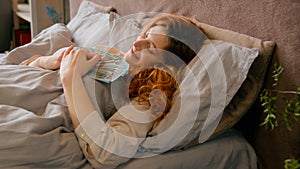 Caucasian happy woman sleeping in bed in luxury vacation with money rich wealthy girl businesswoman holding banknotes