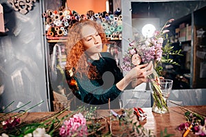 Caucasian hardworking flower asistant concentrating on her work at store