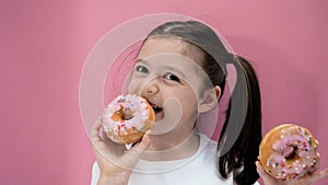 Caucasian healthy preschool kid girl eats donut and smiles. Happy toddler eating healthy organic and homemade food