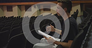 Caucasian high school teenage boy in the auditorium preparing for a performance